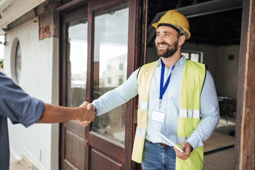 Construction, architect and handshake deal at building for professional contract, trust and welcome