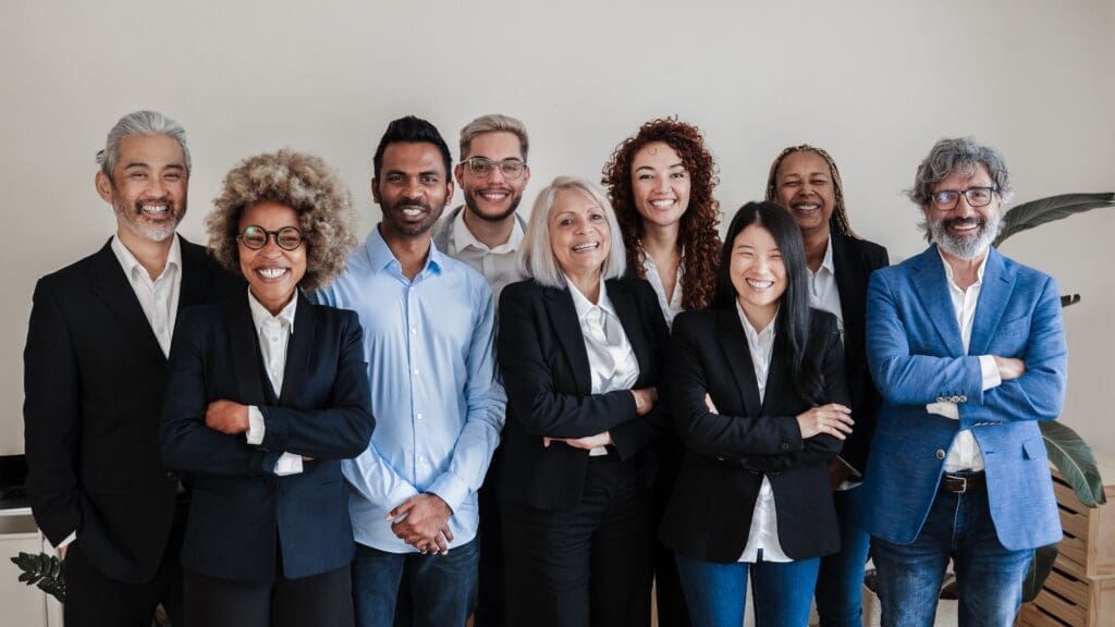 Multiracial generational office: Successful business team smiling on camera - Focus on Asian girl
