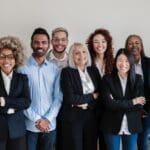 Multiracial generational office: Successful business team smiling on camera - Focus on Asian girl