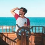 Man Holding Ship's Wheel