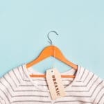 White striped sweatshirt on a hanger and tag with inscription Organic. Eco-friendly clothing