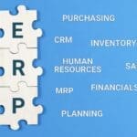 Enterprise Resource Planning concept. Text ERP with jigsaw puzzle pieces on blue background.