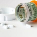 US dollar bills with medicine pills