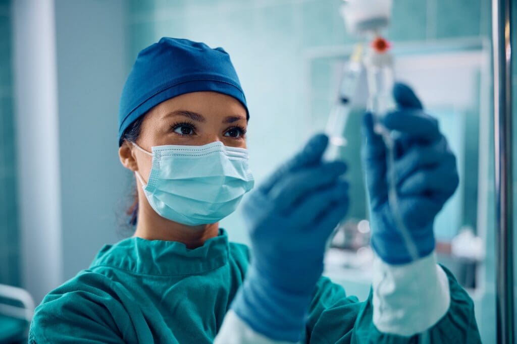 Surgical nurse injecting medicine through IV drip in operating room. Entrepreneurial Success in Pharma
