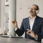 Mature businessman with closed eyes listening to music with headphones