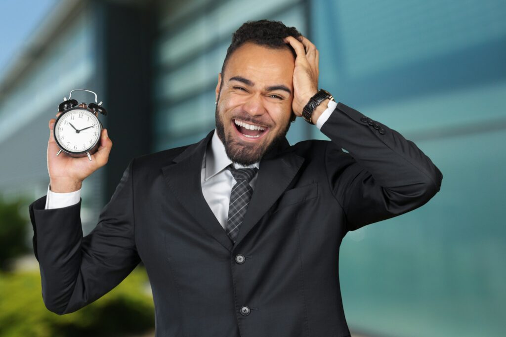 Black businessman with alarm clock. Time management concept