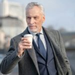 Mature man in elegant coat having coffee