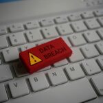 Close up image of computer keyboard and red wooden cube with text DATA BREACH.