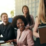 Positive work colleagues smiling together in a modern office