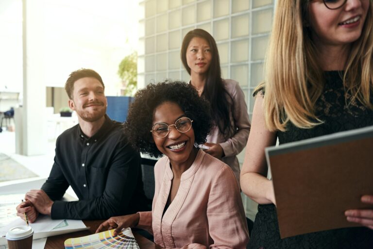 Positive work colleagues smiling together in a modern office