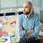 Serious purposeful man thinking about new design project