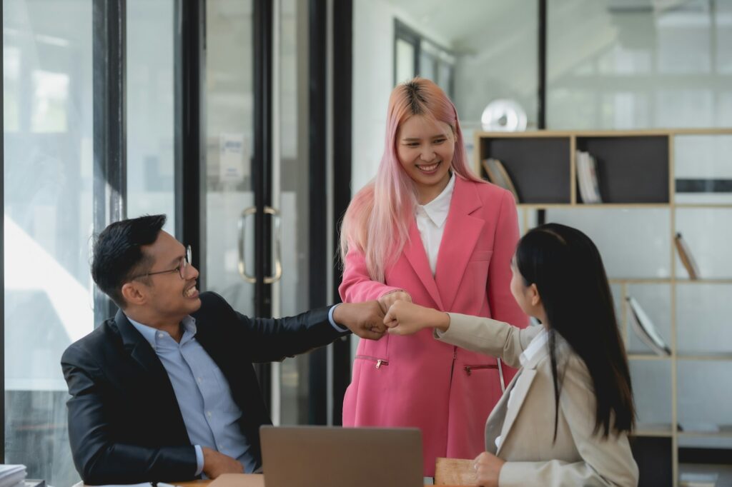 Business team engaging in a fist bump in an office setting. Team building and unity concept.