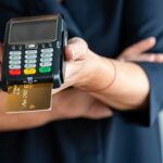 close-up of women hands hold terminal for payment by non-cash money