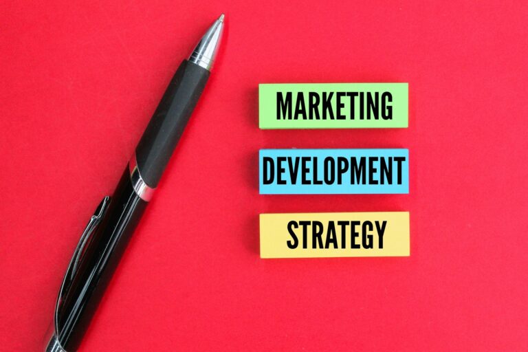 colored pen and paper with the words marketing, development and strategy.