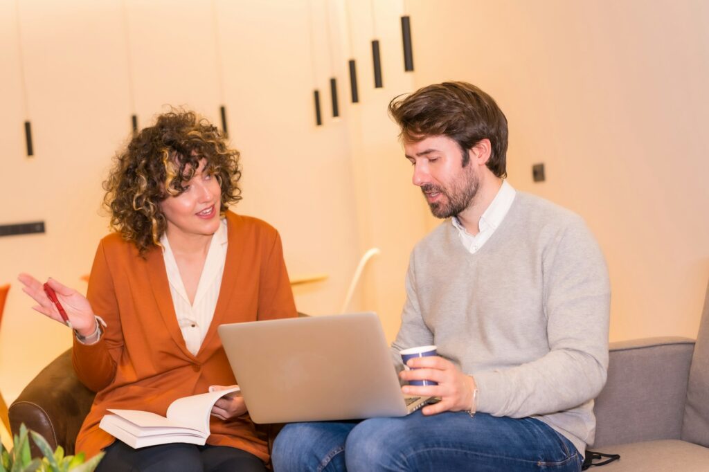 Young entrepreneurs in a business meeting on sofas with a computer and a notepad