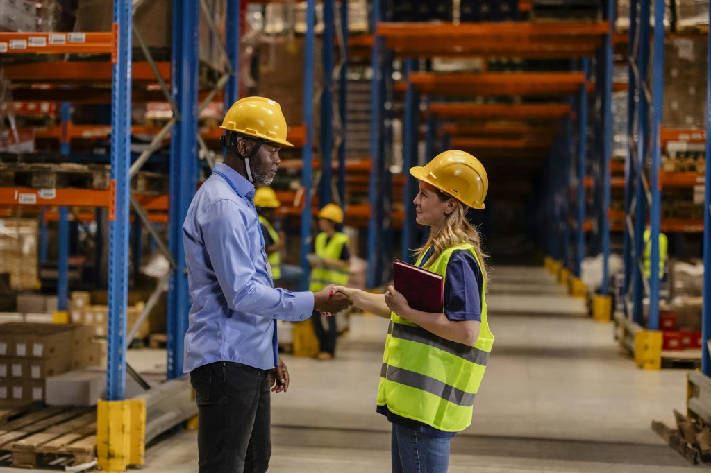 Enculturation in the Workplace: Male and Female Warehouse Workers Shaking Hands
