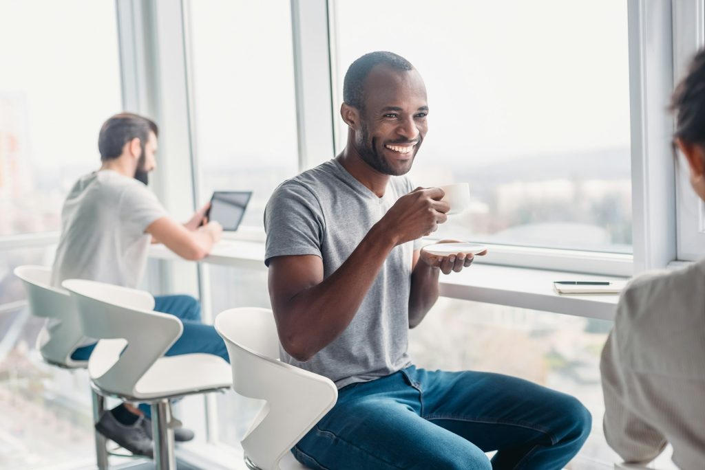 Engaging in cultural norms, colleagues are joking during coffee break at workplace