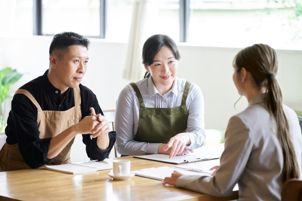 Restaurant manager listening to businesswoman's presentation