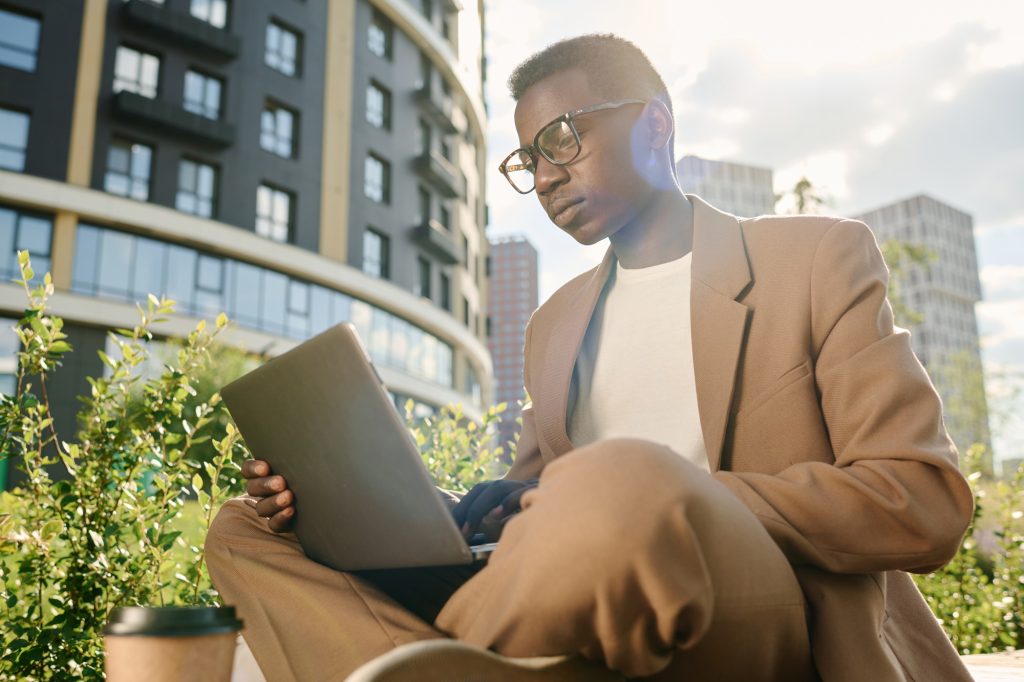 Gen Z Businessman Working On Laptop Outdoors
