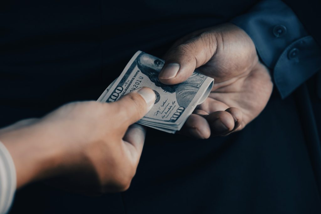 Back side of businessman who give bribe to the Government officials, the concept of corruption