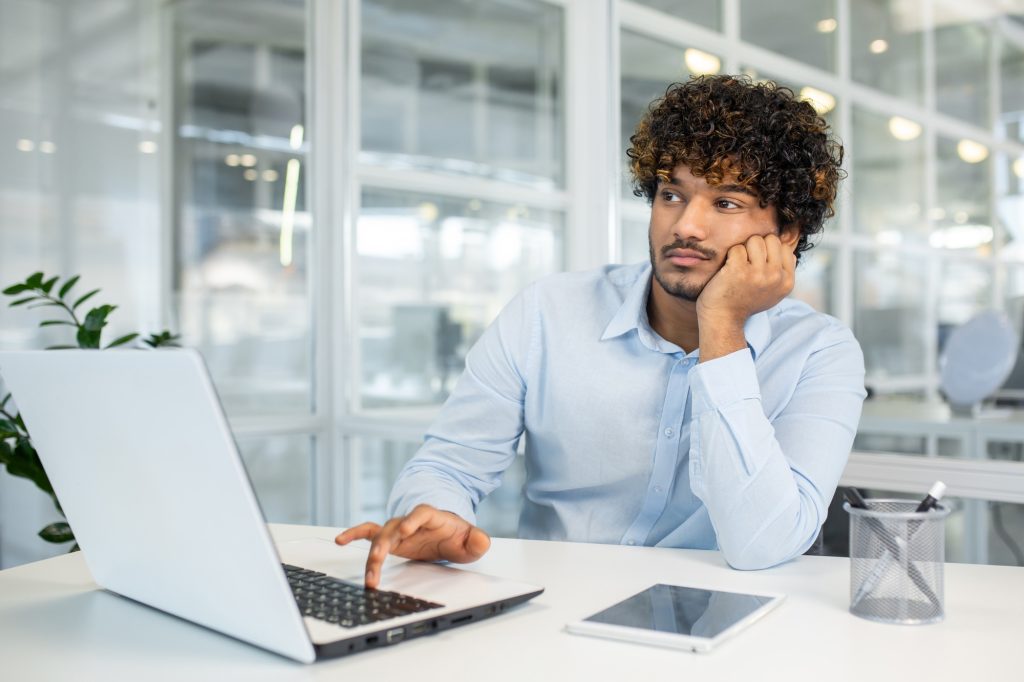 Bored young man staring out window during work