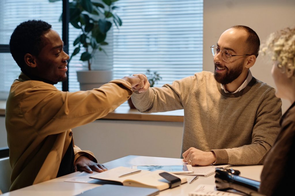 Positive Office Workers Giving Each Other Fist Bump