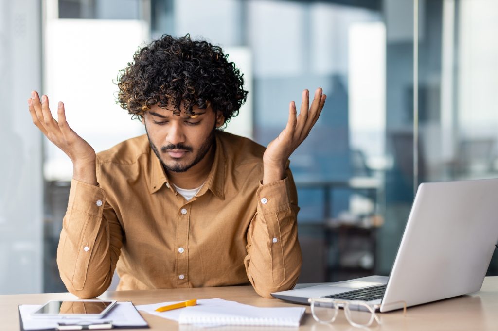 Upset financier looking at sales and revenue chart of company, businessman inside office