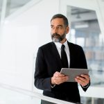 Middle age businessman with tablet in the office