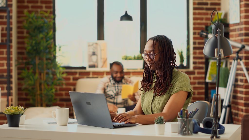 Female freelancer analyzing corporate report on laptop