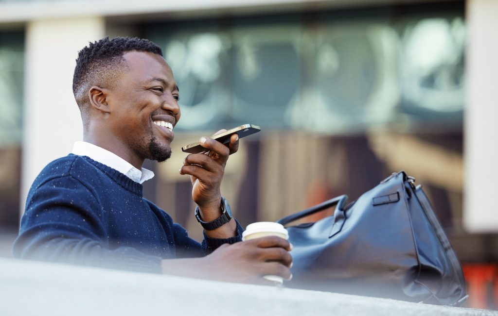 Happy man talking on phone, travel for business in a city, sitting outside while using tech t