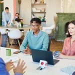 Business meeting where colleagues discuss AI hiring bias in a modern workplace